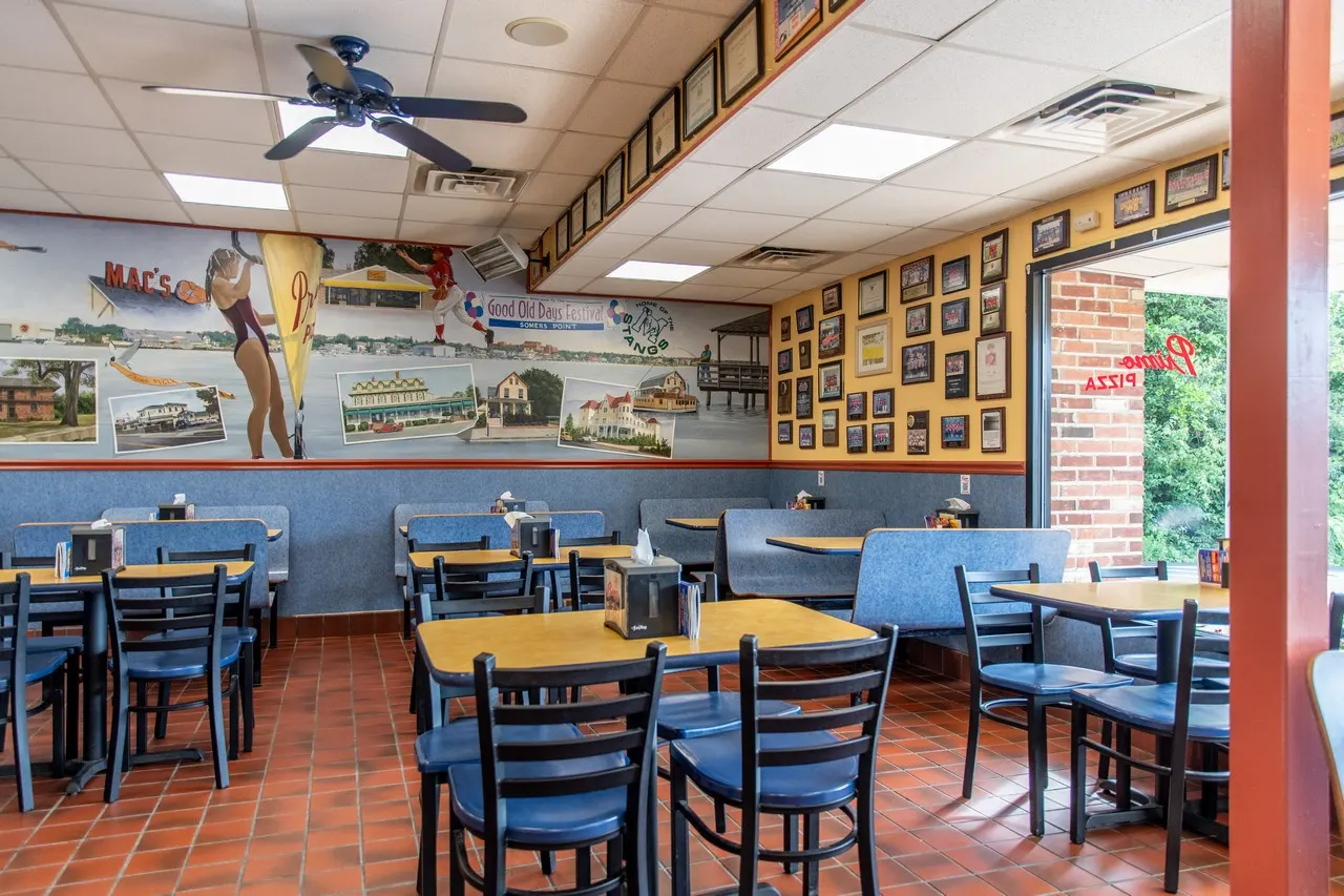The dining room, with a painted wall mural and blue chairs