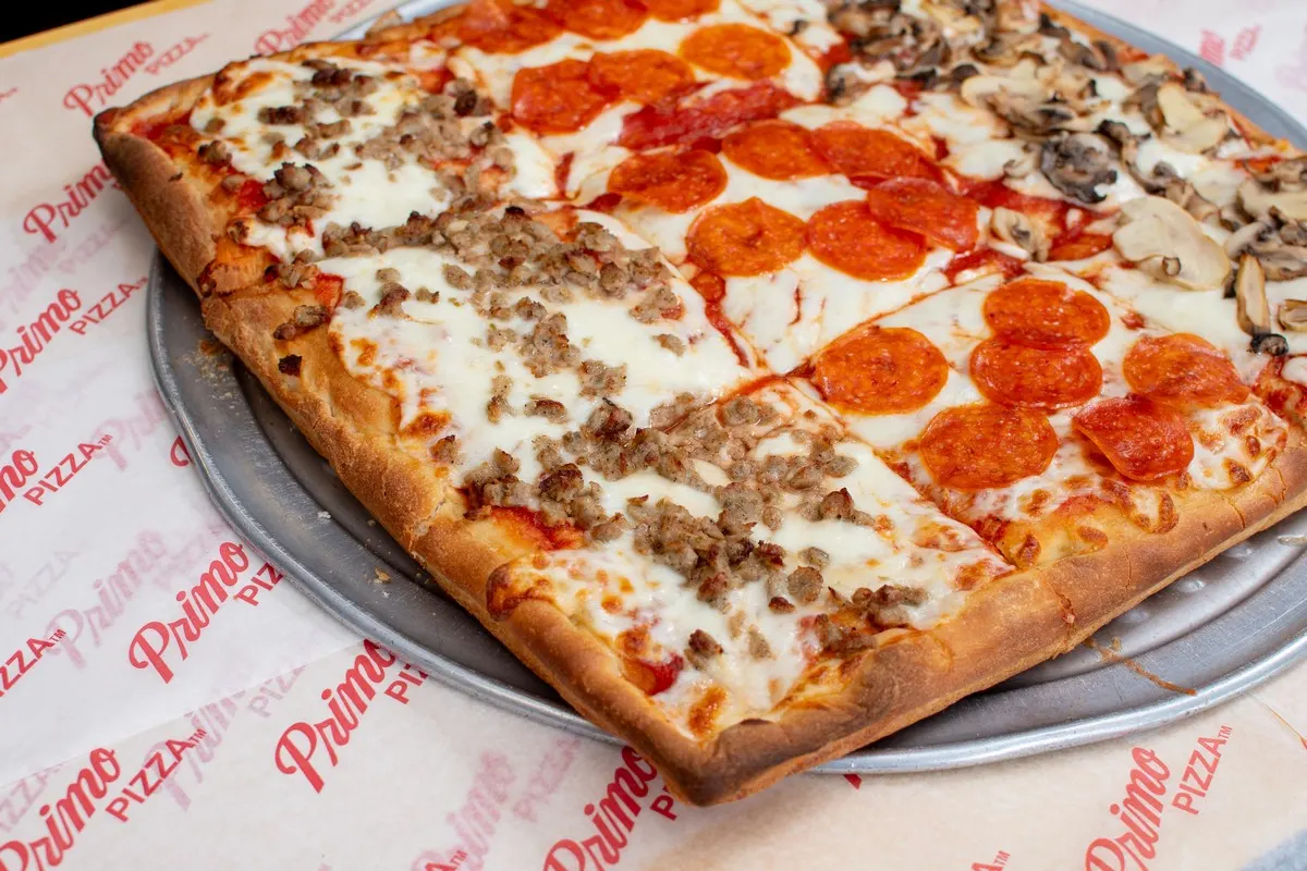 A square pan pizza topped with pepperoni, sausage and mushrooms