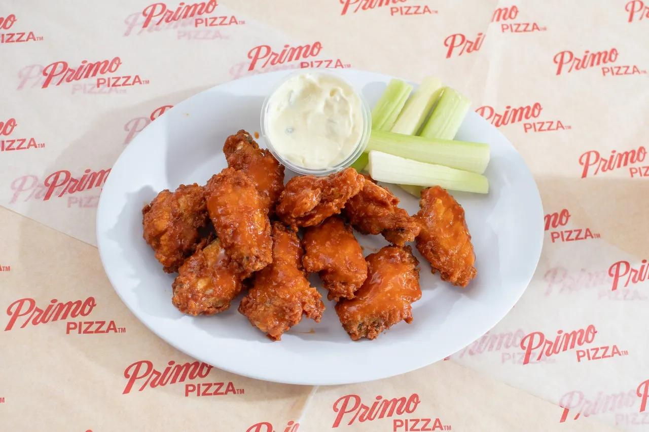 A plate of wings with celery and dip